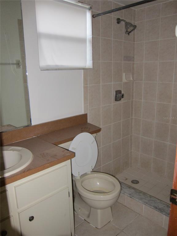 1209 Southwest 80th Drive Gainesville, FL 32607 - Photo 12 of 32 a bathroom with a granite countertop toilet a sink and shower