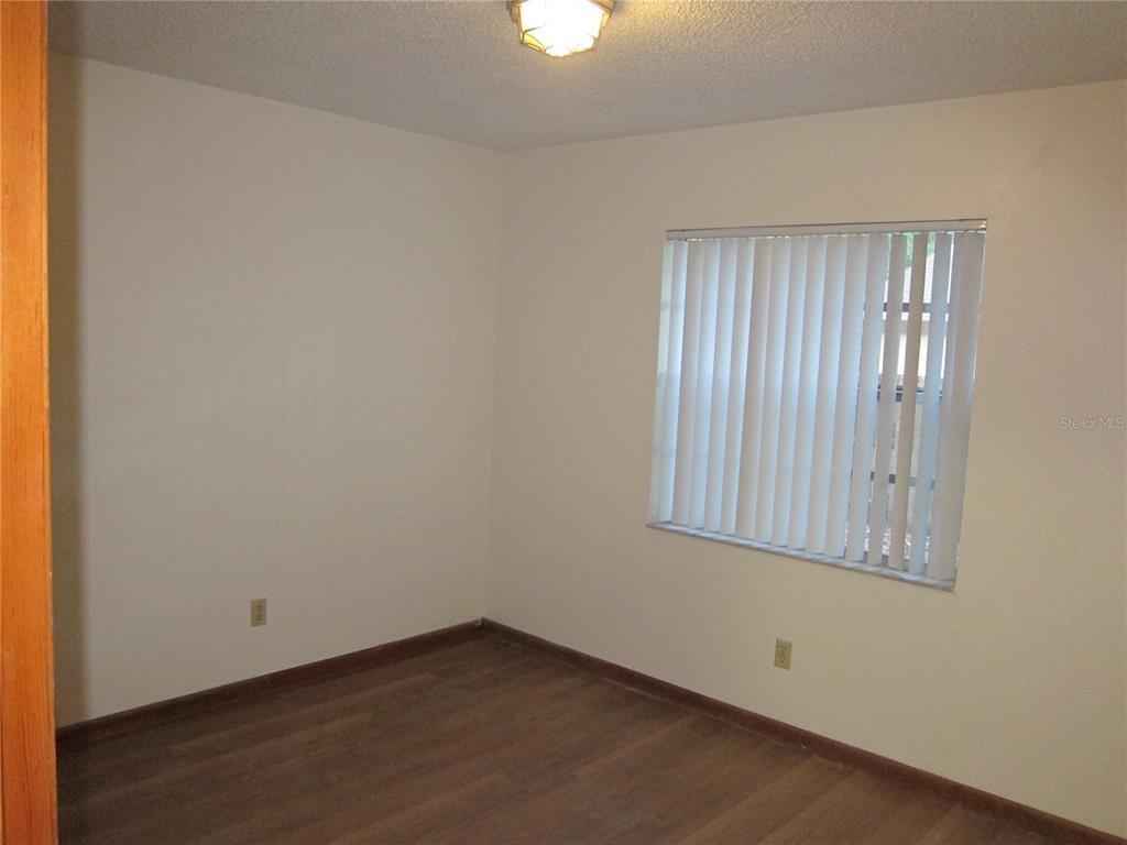 1209 Southwest 80th Drive Gainesville, FL 32607 - Photo 27 of 32 an empty room with wooden floor and windows