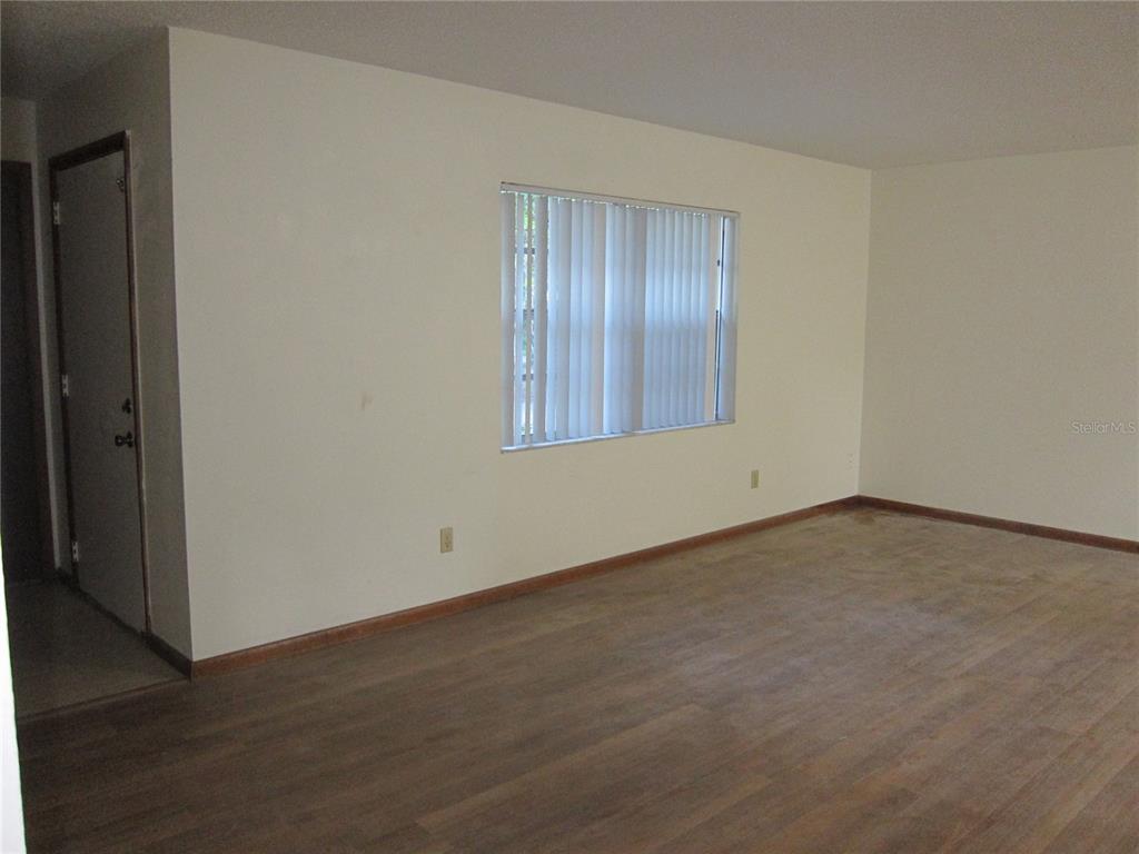 1209 Southwest 80th Drive Gainesville, FL 32607 - Photo 5 of 32 an empty room with wooden floor and windows