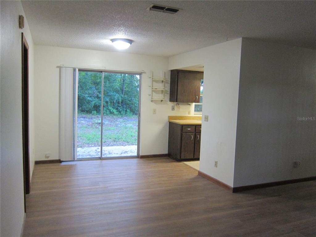 1209 Southwest 80th Drive Gainesville, FL 32607 - Photo 7 of 32 a view of an empty room with a window and wooden floor