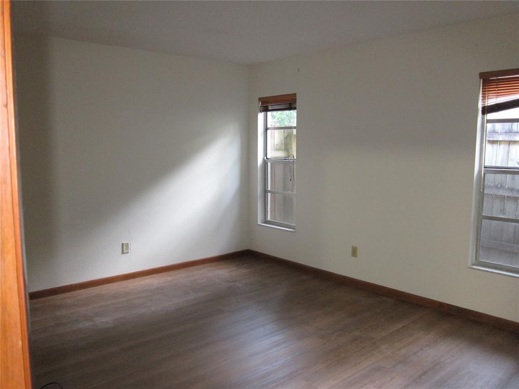 1209 Southwest 80th Drive Gainesville, FL 32607 - Photo 9 of 32 an empty room with wooden floor and windows