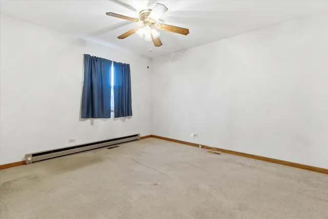 a view of an empty room with a chandelier fan