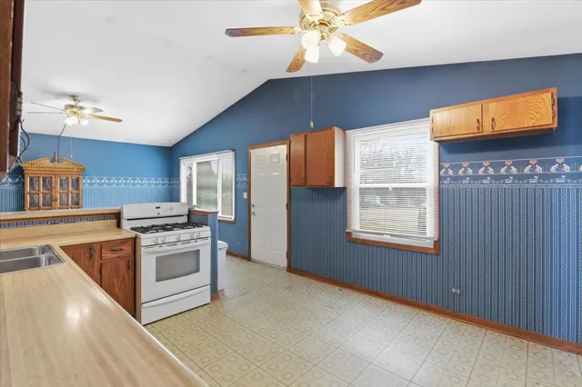 a kitchen with stainless steel appliances granite countertop a stove a sink and a microwave