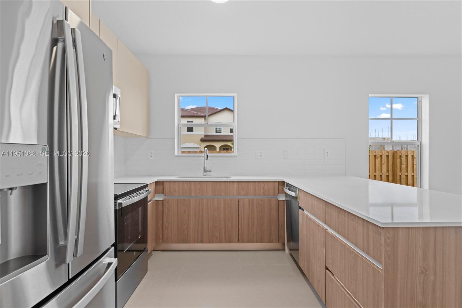 13350 Southwest 272nd Street Homestead, FL 33032 - Photo 12 of 35 a kitchen with stainless steel appliances granite countertop a refrigerator and a sink