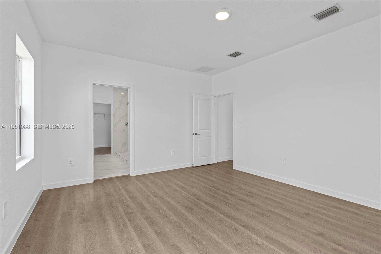 13350 Southwest 272nd Street Homestead, FL 33032 - Photo 24 of 35 a view of an empty room with wooden floor and a window