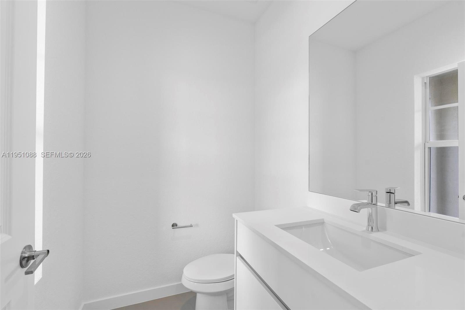 13350 Southwest 272nd Street Homestead, FL 33032 - Photo 4 of 35 a bathroom with a sink a toilet and a mirror