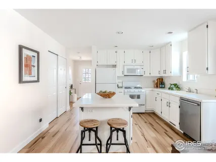 a kitchen with white cabinets and white appliances