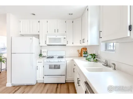a kitchen with white cabinets and white appliances