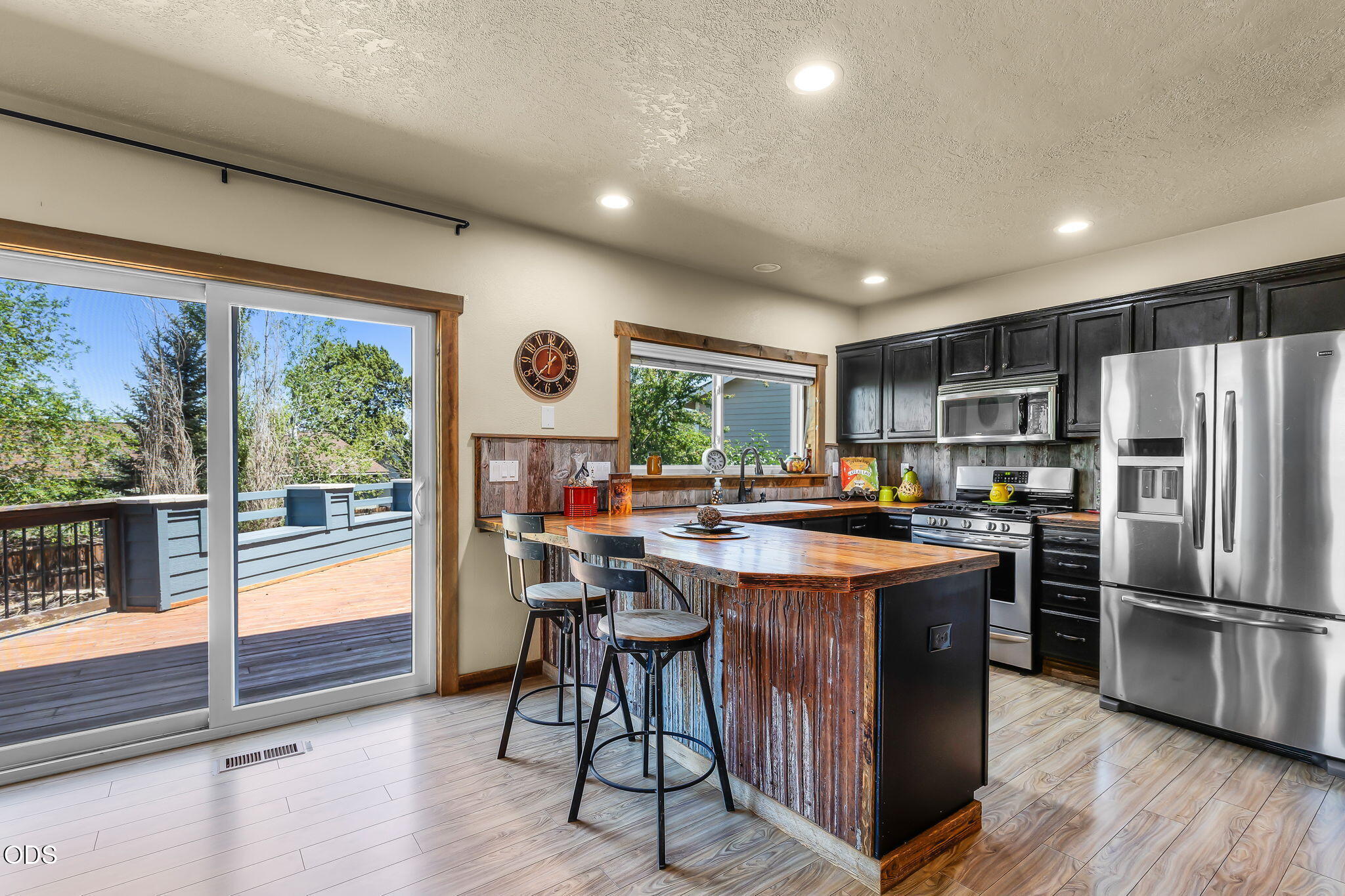 2486 Southwest Valleyview Drive Redmond, OR 97756 - Photo 9 of 55 a kitchen with stainless steel appliances granite countertop a refrigerator a sink dishwasher a stove and white countertops with wooden floor