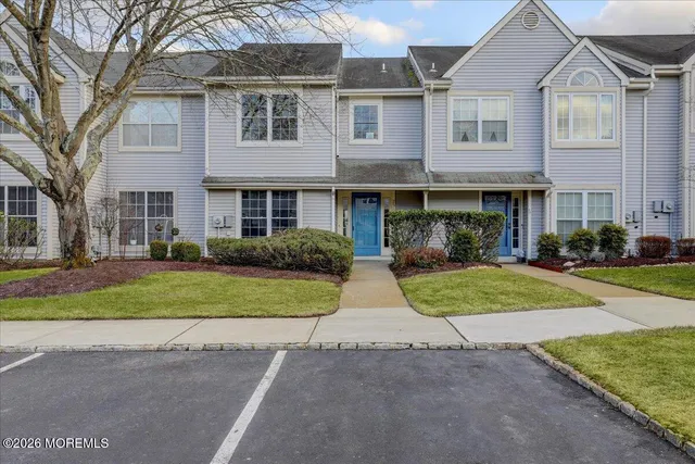a front view of a house with a yard and potted plants
