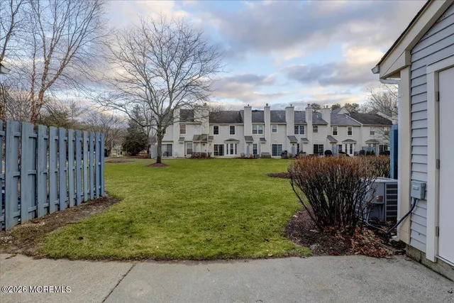 a view of a garden with a bench in front of house
