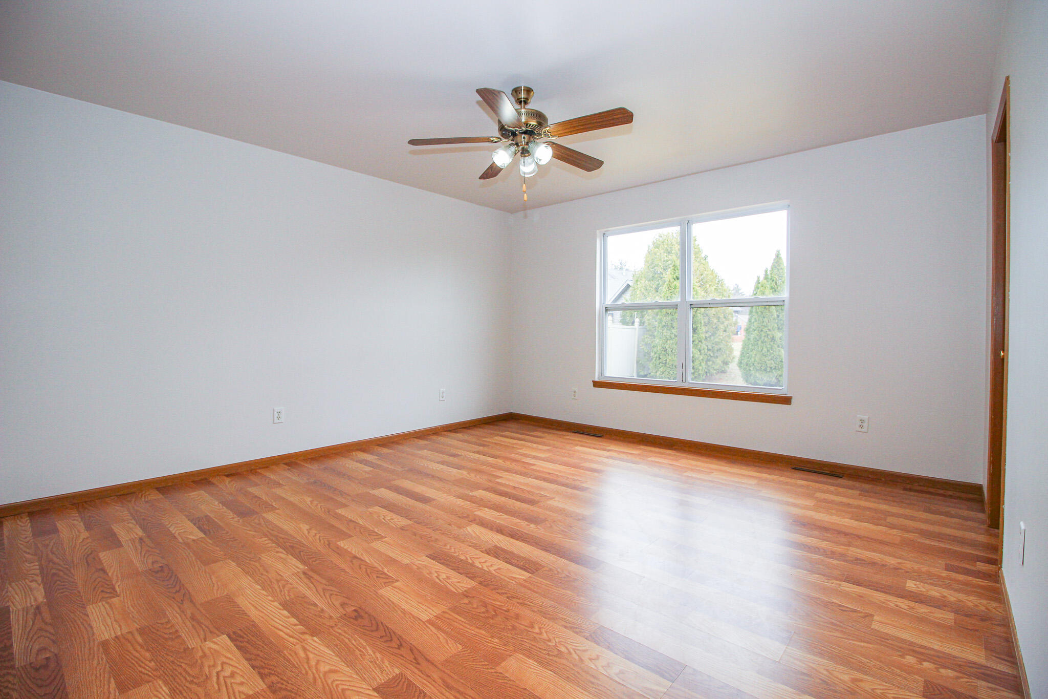1709 Daisy Street Southeast De Motte, IN 46310 - Photo 11 of 19 an empty room with wooden floor chandelier fan and windows