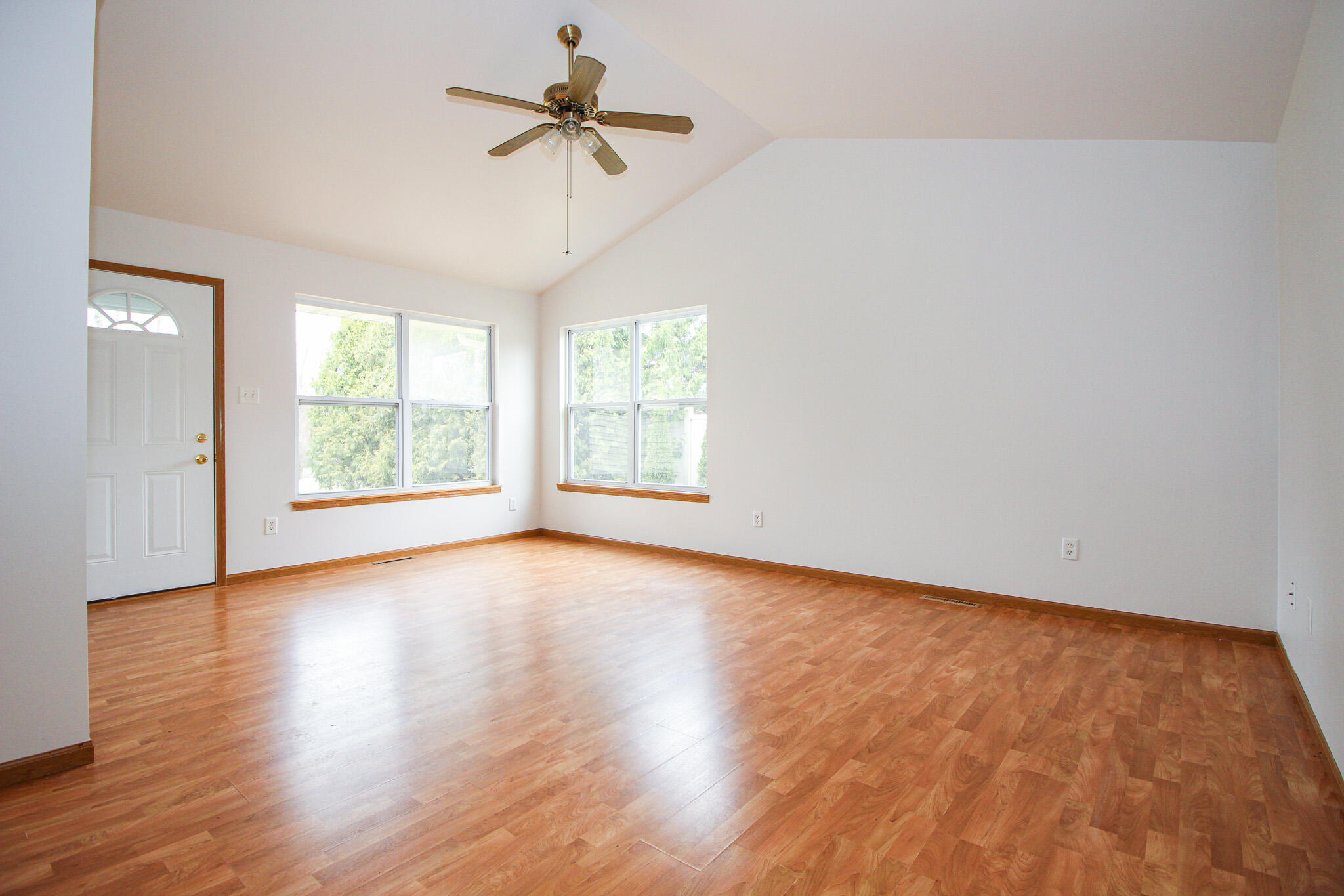 1709 Daisy Street Southeast De Motte, IN 46310 - Photo 3 of 19 an empty room with wooden floor chandelier fan and windows