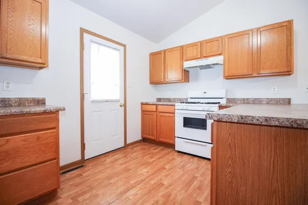 a kitchen with stainless steel appliances granite countertop a stove a sink and a refrigerator