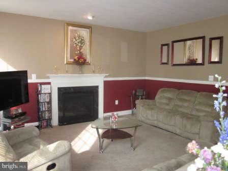 16501 Telescope Lane Dumfries, VA 22026 - Photo 9 of 30 a living room with furniture a flat screen tv and a fireplace