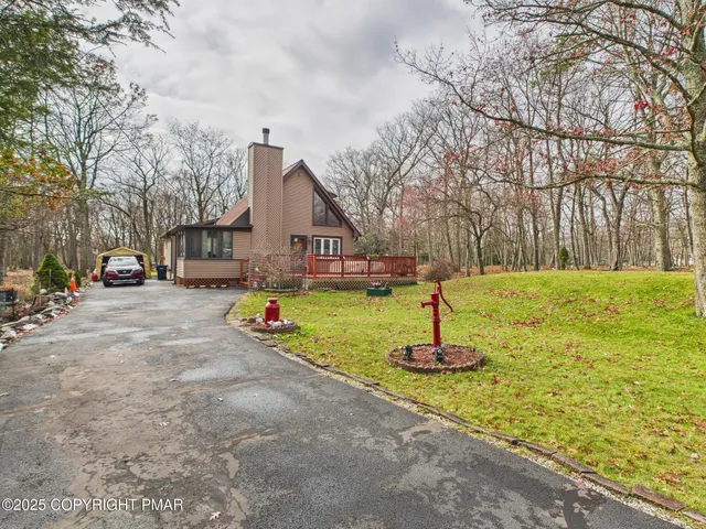 a front view of a house with a yard fire pit and trees