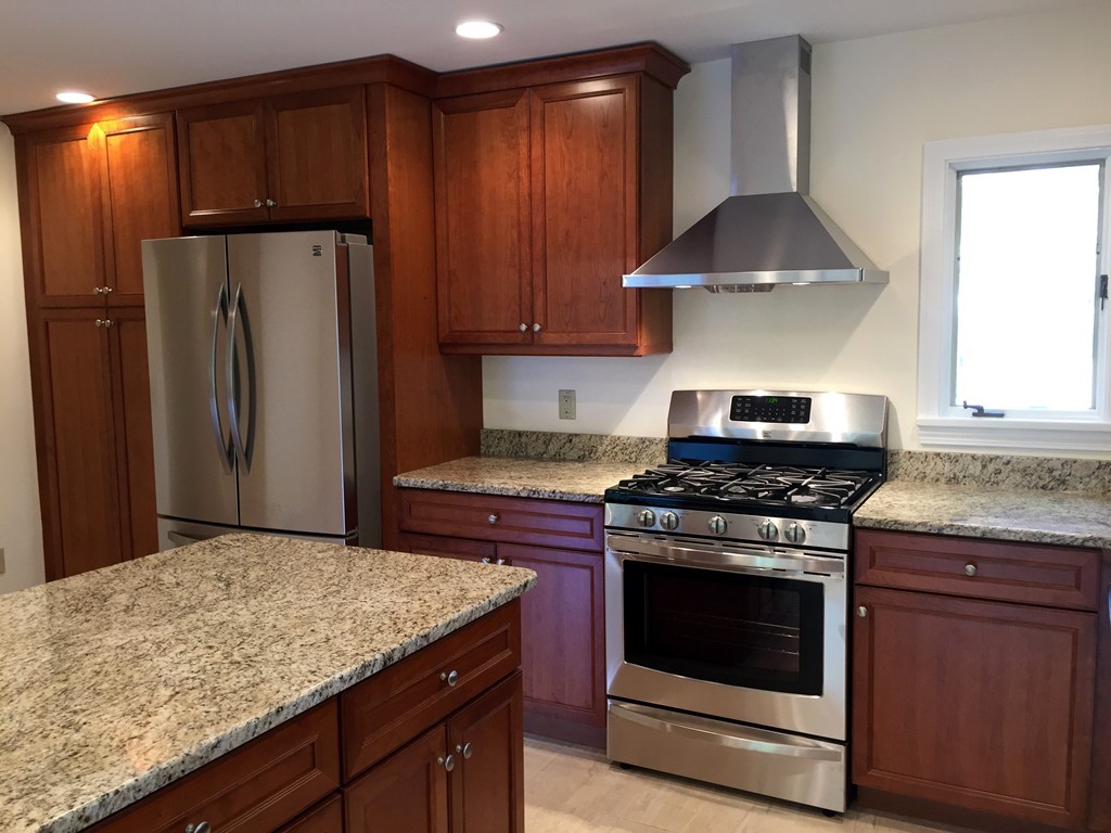 18 Massasoit Road Wellesley, MA 02481 - Photo 2 of 13 a kitchen with granite countertop a stove and a refrigerator