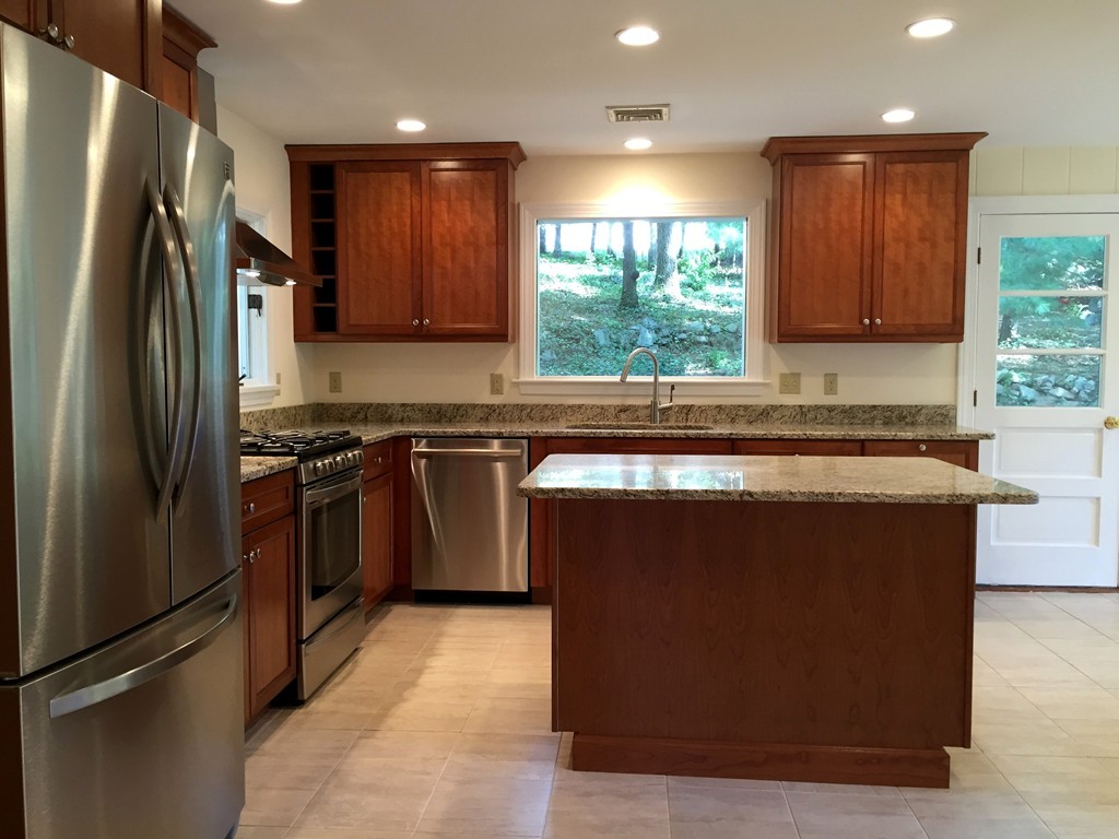 18 Massasoit Road Wellesley, MA 02481 - Photo 3 of 13 a kitchen with stainless steel appliances granite countertop a refrigerator a sink a stove a microwave and island