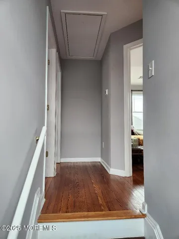 a view of a hallway view with wooden floor and staircase