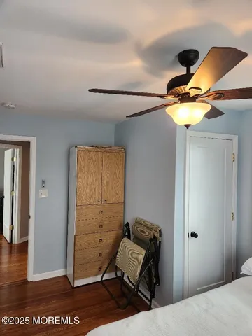 a bedroom with a bed and a chandelier fan