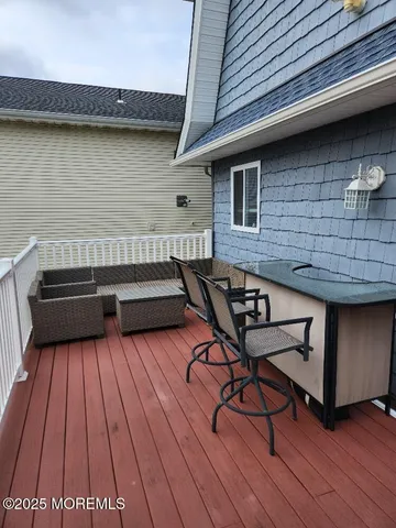 a terrace of a house with wooden floor and outdoor seating