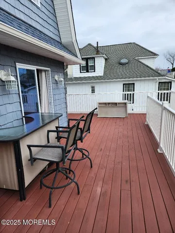 a view of a patio with table and chairs with wooden floor and fence