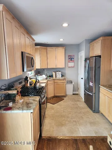 a kitchen with refrigerator a stove a sink a microwave and cabinets