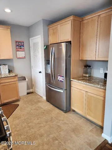 a kitchen with a refrigerator sink and cabinets