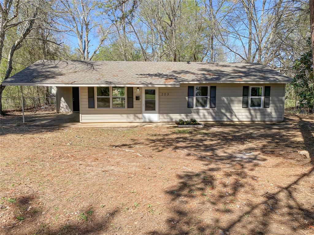 Single story home featuring an attached carport and roof with shingles