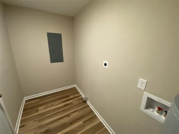 a view of a room with wooden floor and small window