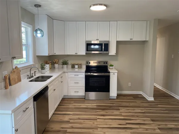 a kitchen with stainless steel appliances granite countertop a stove a sink and a refrigerator