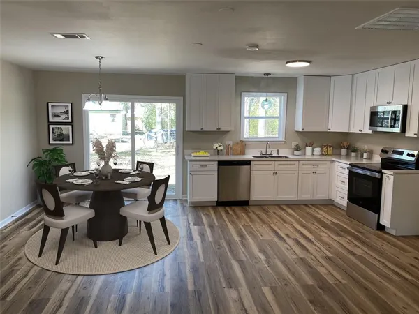 a kitchen with a table chairs sink and cabinets