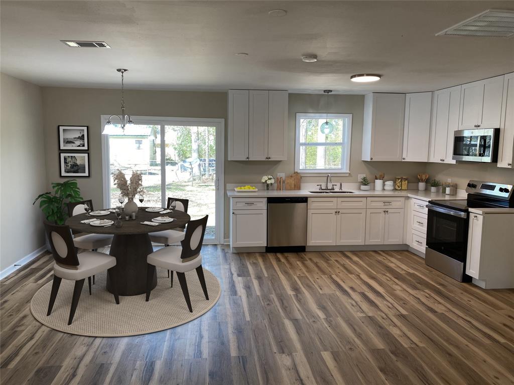 203 Elam Street Mansfield, LA 71052 - Photo 5 of 18 a kitchen with a table chairs sink and cabinets