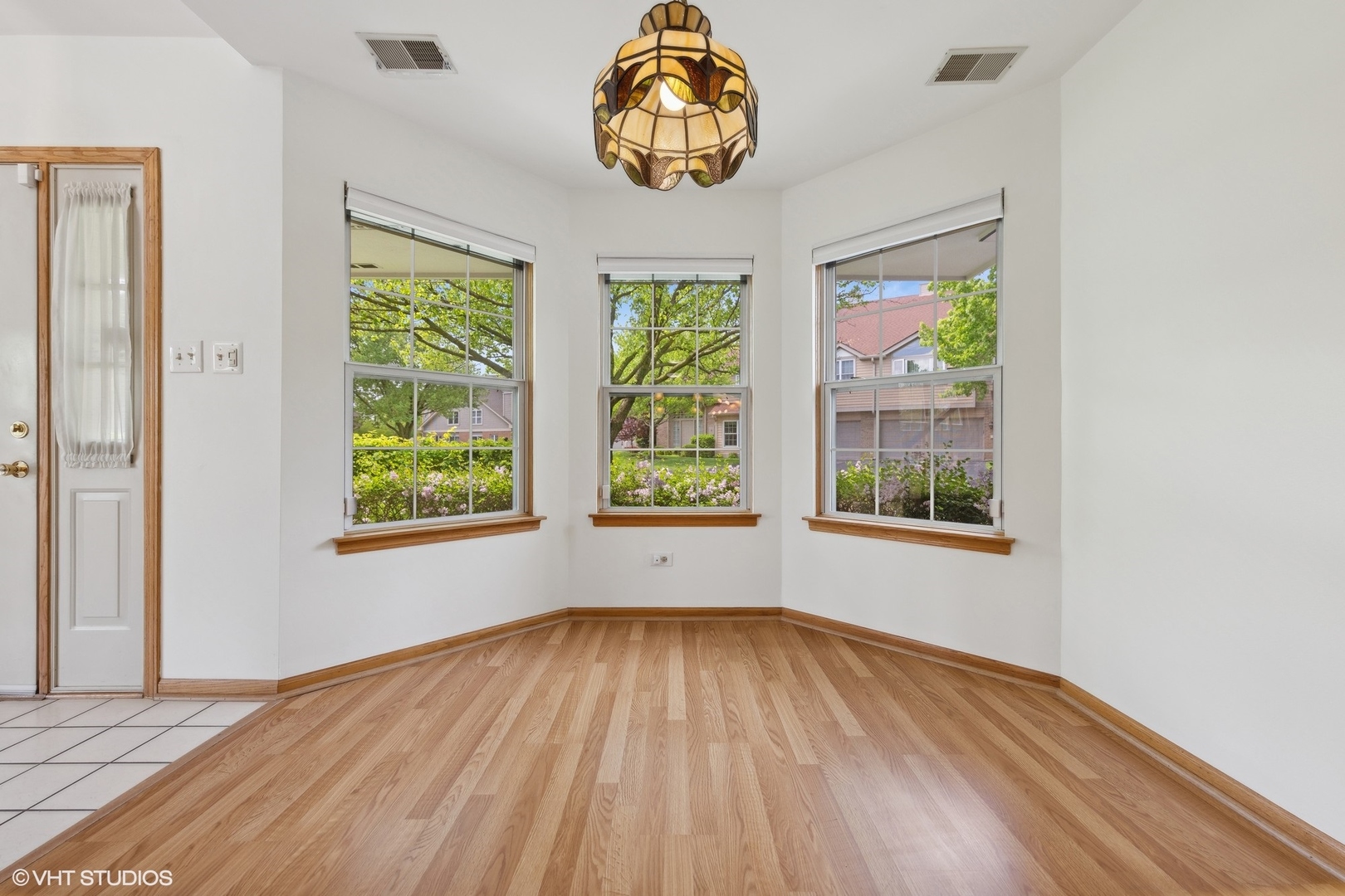 8060 Capra Trail Darien, IL 60561 - Photo 12 of 21 a view of an empty room with a window and wooden floor