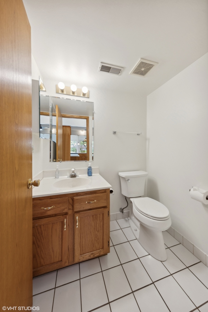 8060 Capra Trail Darien, IL 60561 - Photo 8 of 21 a bathroom with a toilet sink and mirror