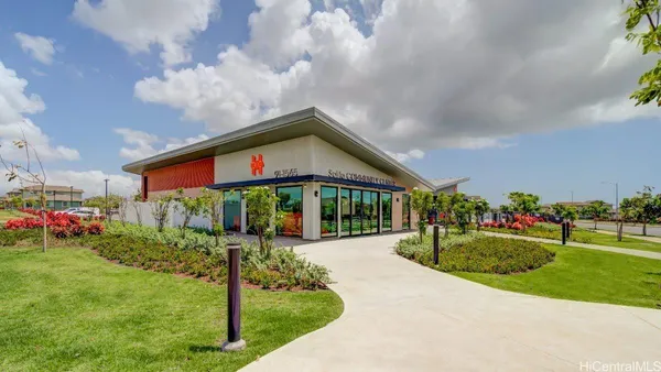 a sign of golf club on a wall under a tree