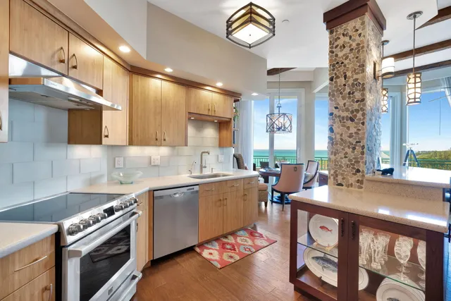 a kitchen with stainless steel appliances granite countertop a sink a stove and a refrigerator