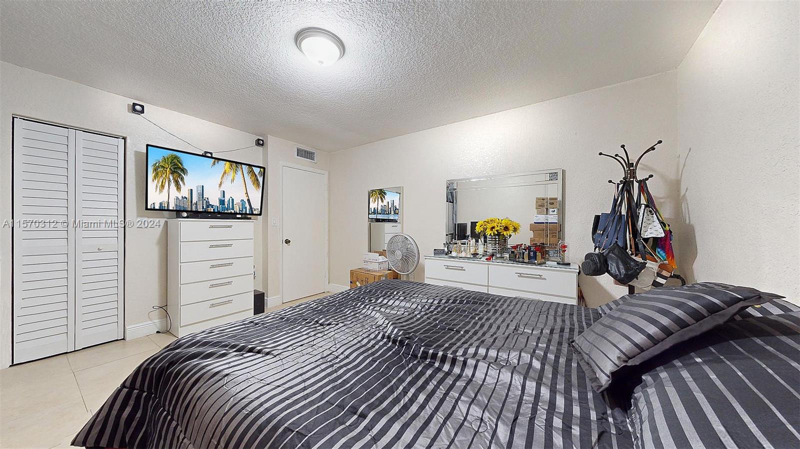9483 Southwest 76th Street, Unit N3 Miami, FL 33173 - Photo 17 of 27 a bedroom with furniture and a flat screen tv