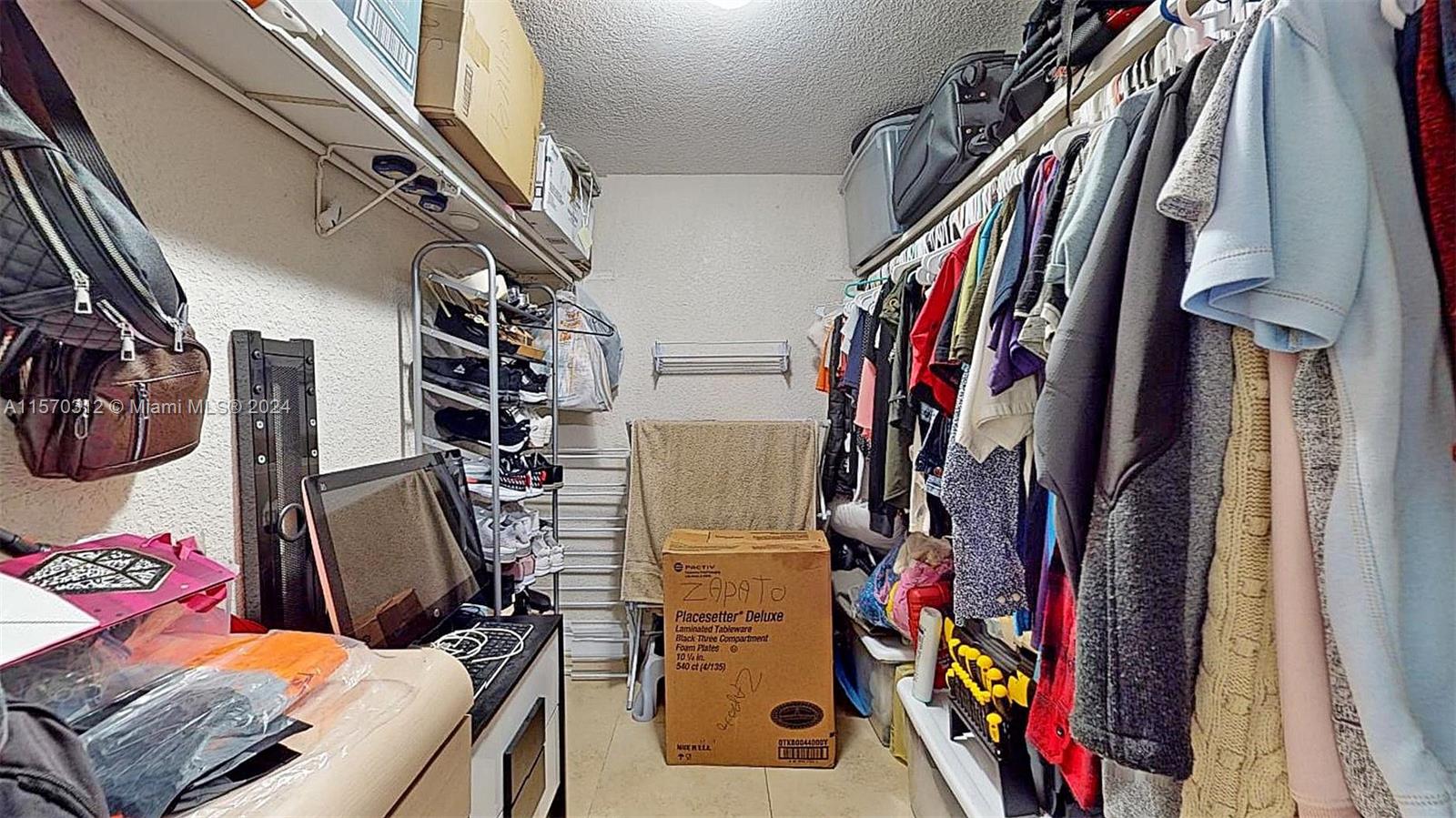 9483 Southwest 76th Street, Unit N3 Miami, FL 33173 - Photo 18 of 27 a view of walk in closet with clothes and shoes