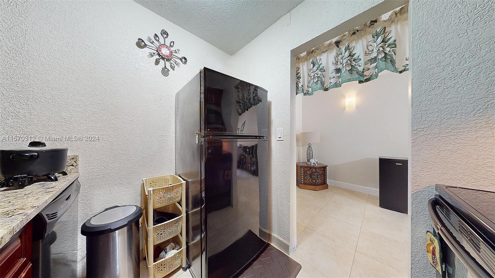 9483 Southwest 76th Street, Unit N3 Miami, FL 33173 - Photo 9 of 27 a kitchen with a refrigerator and a stove
