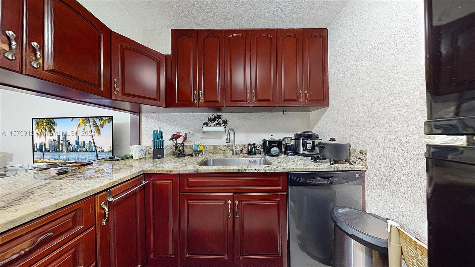 9483 Southwest 76th Street, Unit N3 Miami, FL 33173 - Photo 10 of 27 a kitchen with stainless steel appliances granite countertop a sink stove and cabinets