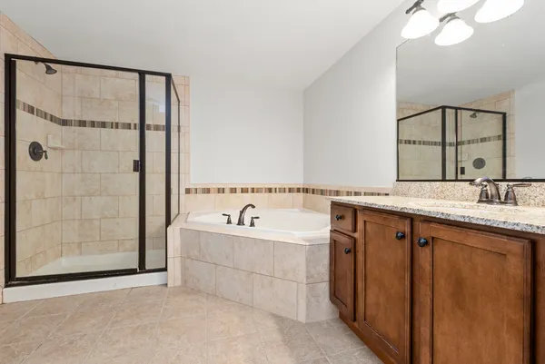 a spacious bathroom with a tub a sink and mirror