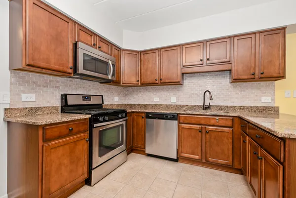 a kitchen with stainless steel appliances granite countertop a sink stove and microwave
