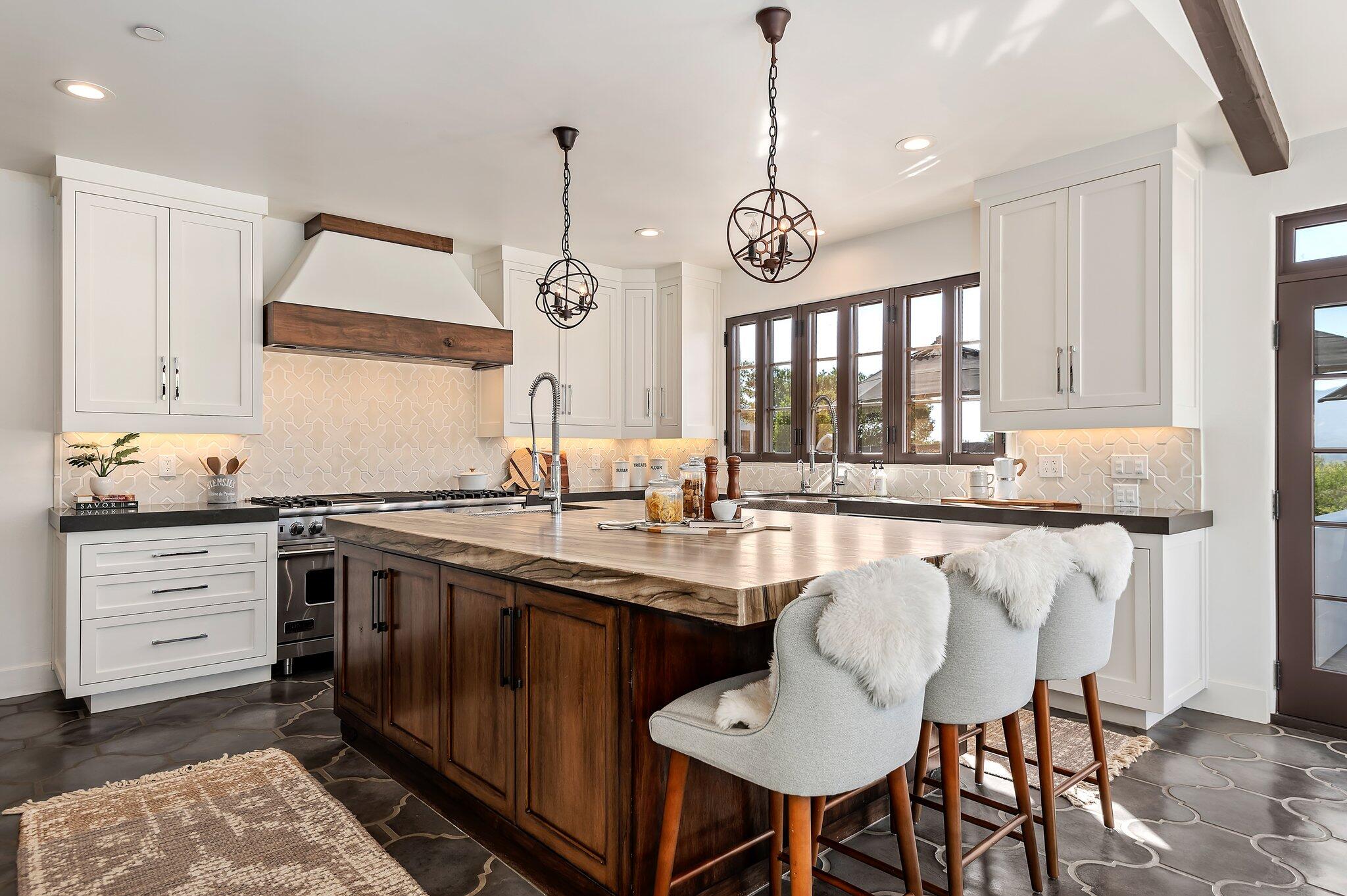 695 Via Hierba Santa Barbara, CA 93110 - Photo 19 of 70 a kitchen with stainless steel appliances granite countertop a sink a stove and chairs with wooden floor