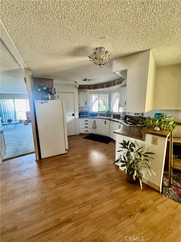 8651 Foothill, Unit 157 Rancho Cucamonga, CA 91730 - Photo 7 of 13 a view of a room with shelves wooden floor and a chandelier
