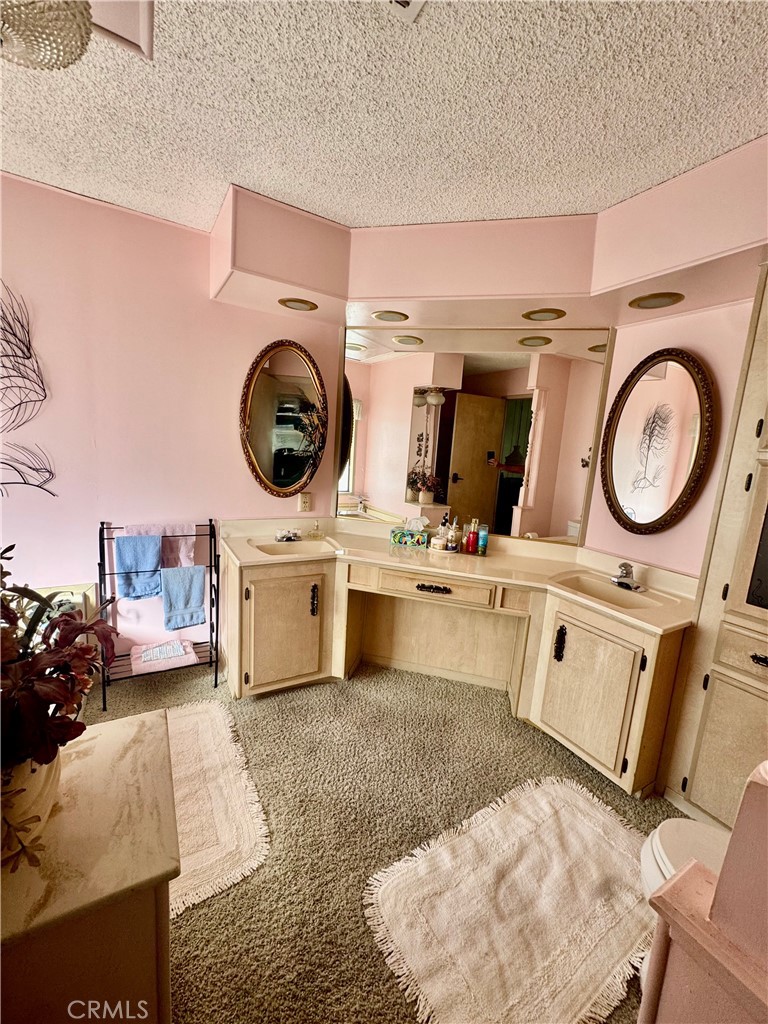 8651 Foothill, Unit 157 Rancho Cucamonga, CA 91730 - Photo 10 of 13 a kitchen with kitchen island a stove a chimney a sink and cabinets