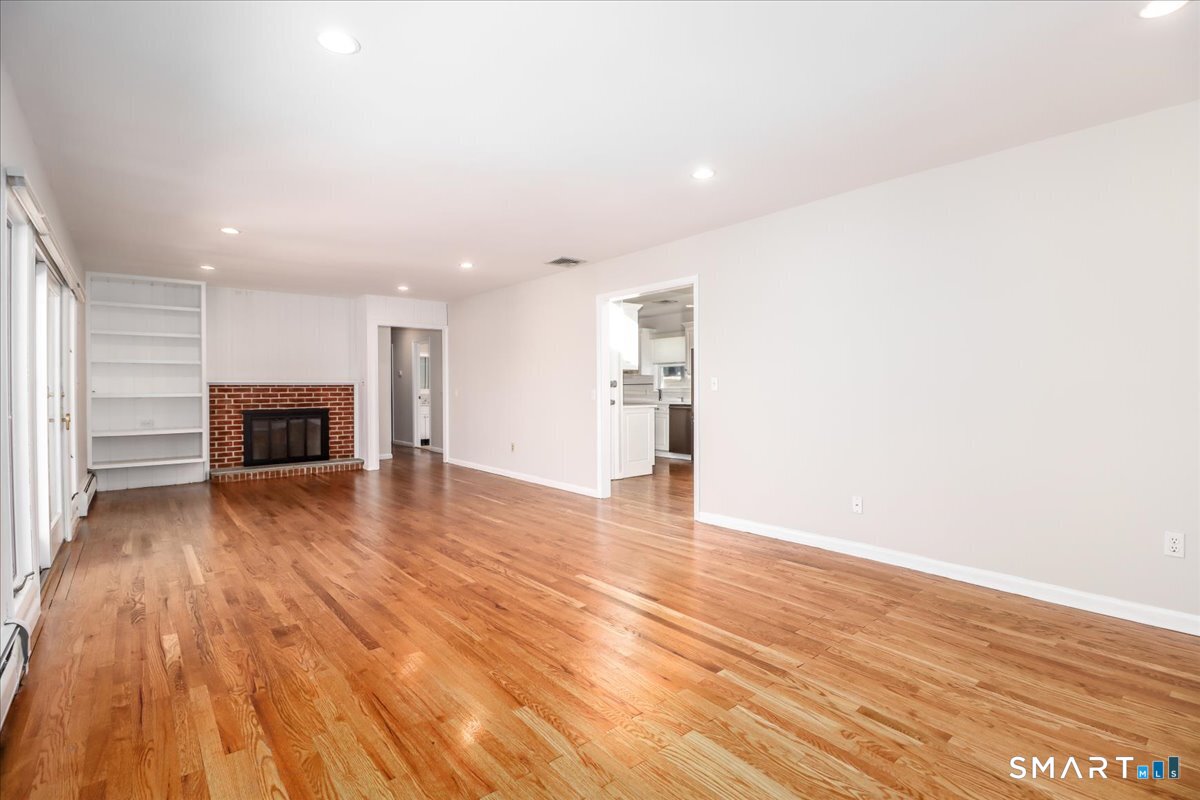 12 South Mountain Road Brookfield, CT 06804 - Photo 9 of 39 a view of empty room with wooden floor and fireplace