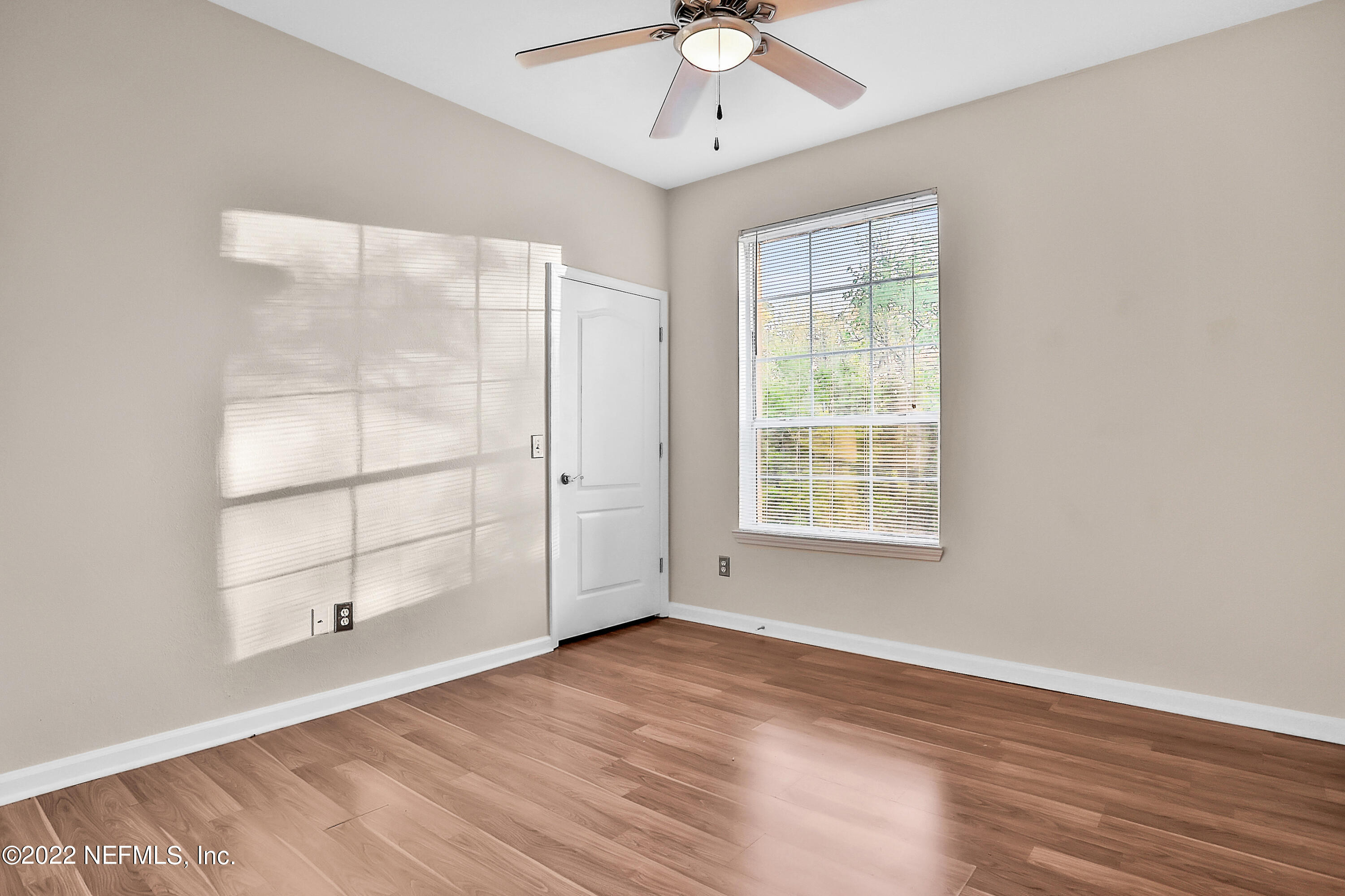 8601 Beach Boulevard, Unit 511 Jacksonville, FL 32216 - Photo 21 of 25 an empty room with wooden floor cabinet and windows