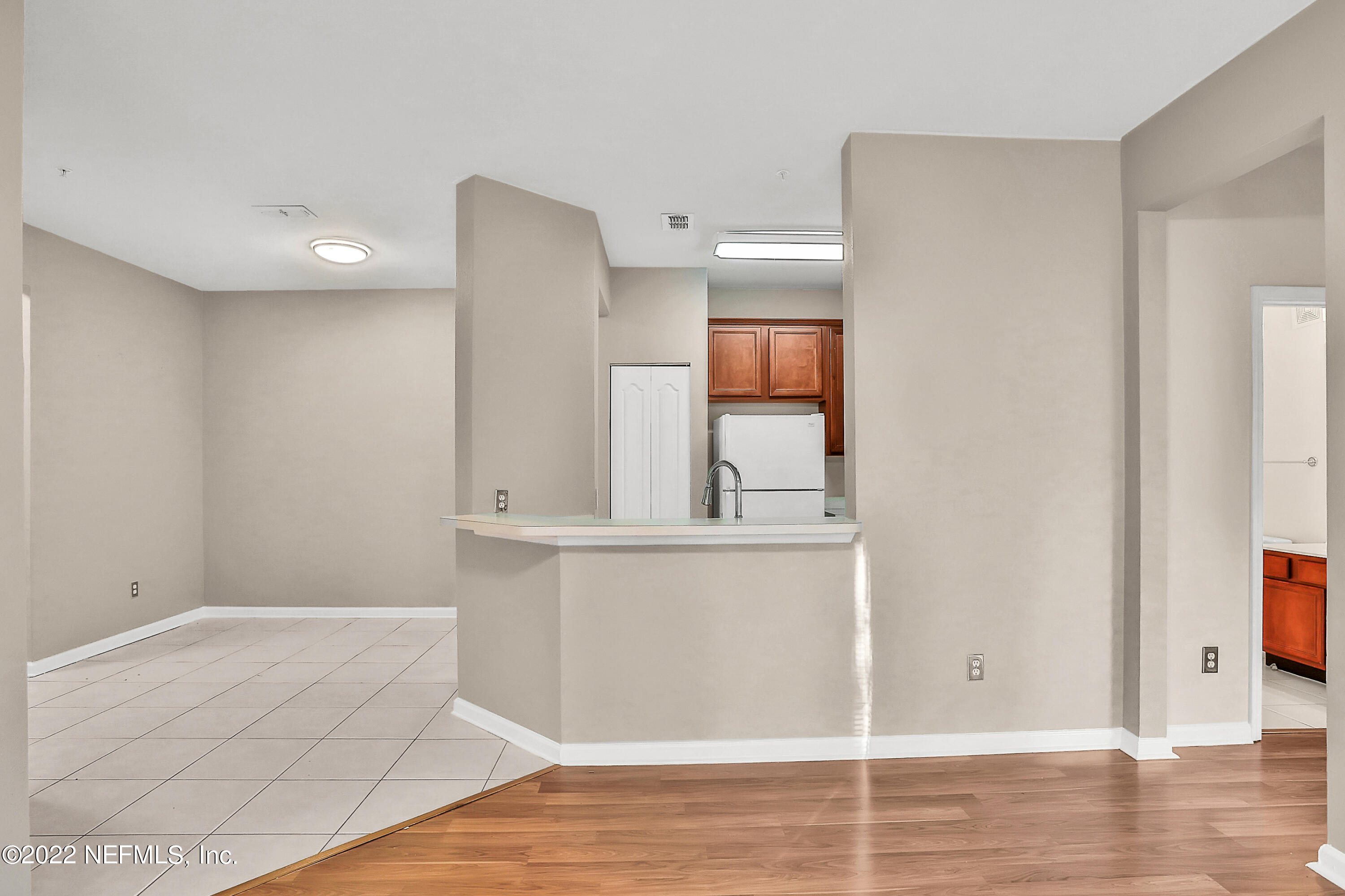 8601 Beach Boulevard, Unit 511 Jacksonville, FL 32216 - Photo 9 of 25 a view of a hallway with wooden floor and cabinet