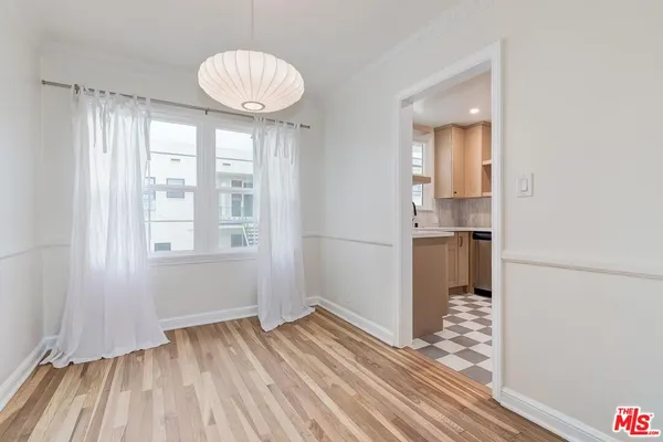 a view of empty room with wooden floor and window